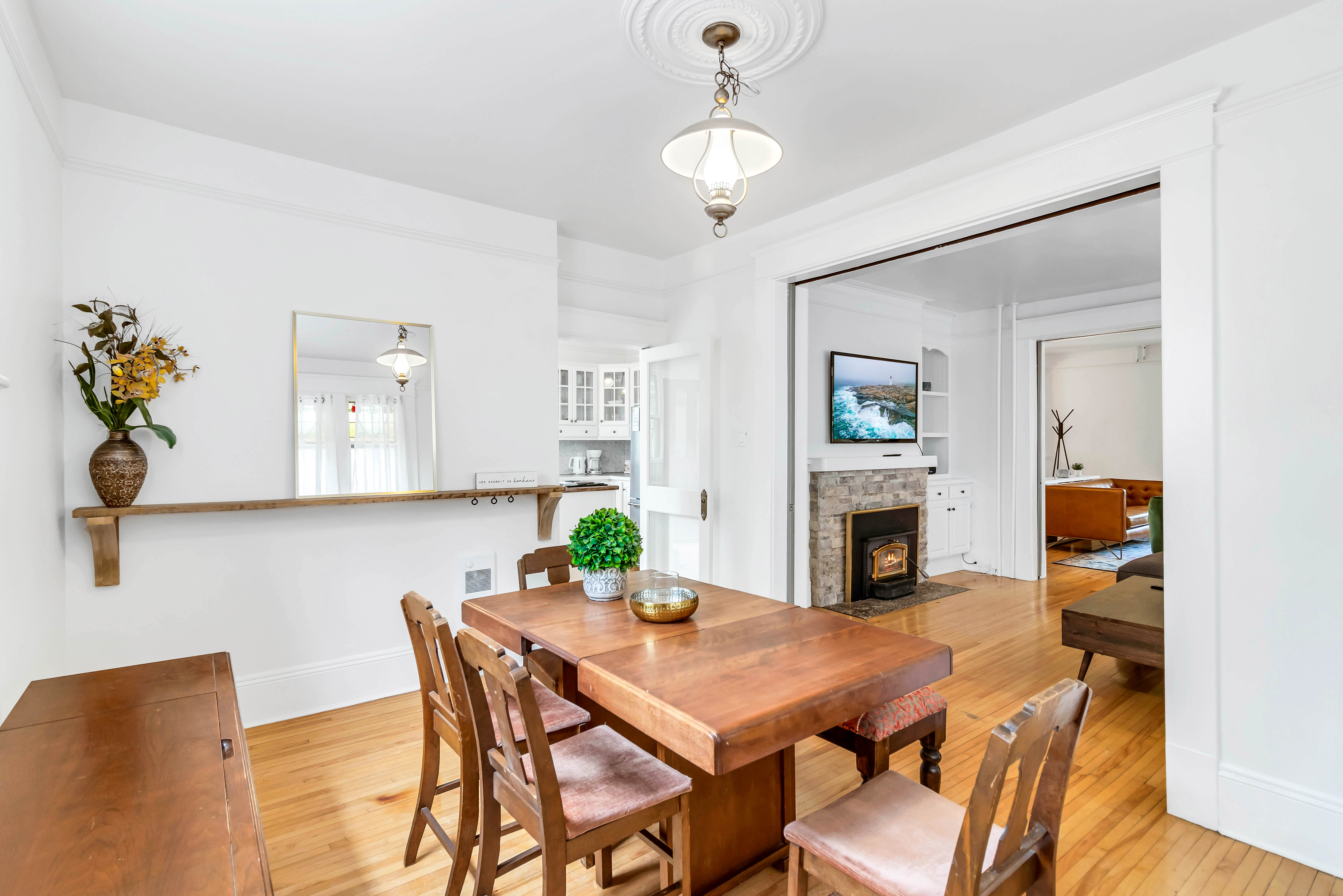 Charming dining room with vintage wooden table and chairs, centered under a traditional ceiling medallion and pendant light.