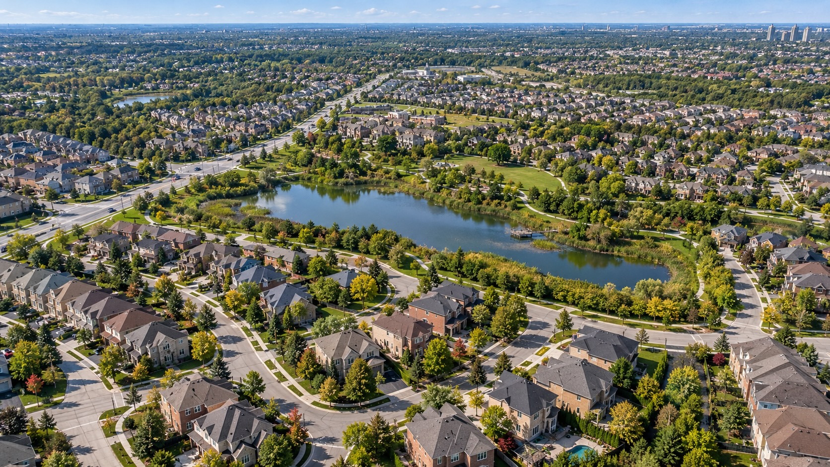 Aerial view of family homes surrounding a neighbourhood pond and parkland