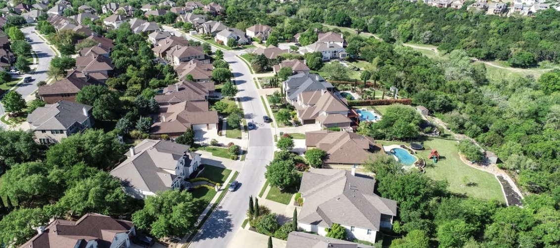 Aerial view of detached homes backing onto a wooded ravine